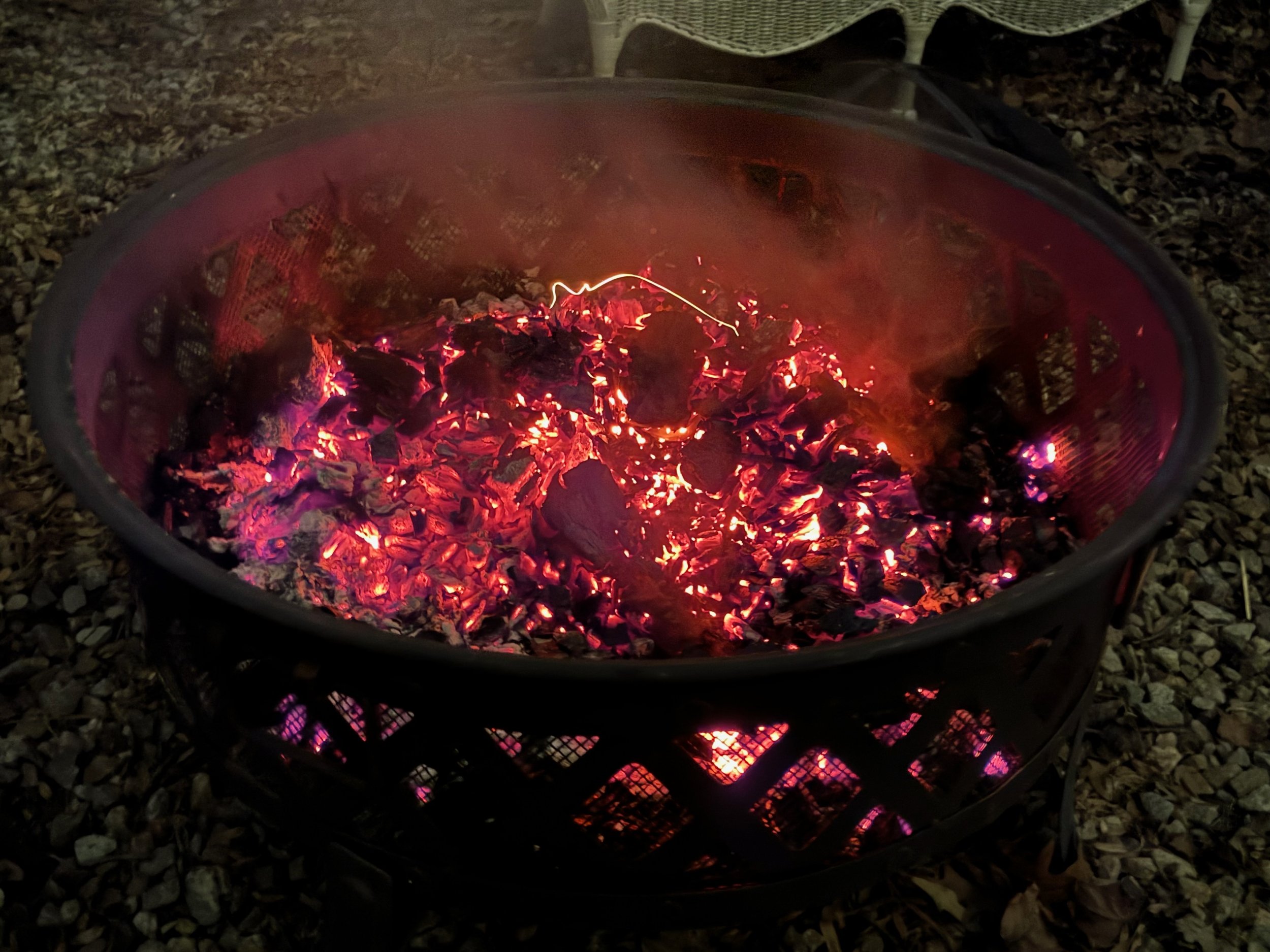 An outdoor fire pit full of glowing coals